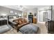 Relaxing bedroom featuring a comfortable sofa, a large bed, and two decorative pictures at 7288 Olsen Farm St, Las Vegas, NV 89131