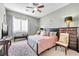 Bedroom with a window with shutters, carpet flooring, an accent wall, and a ceiling fan at 7288 Olsen Farm St, Las Vegas, NV 89131