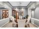 Elegant dining area with stylish decor and a wooden table with cream colored chairs at 7288 Olsen Farm St, Las Vegas, NV 89131