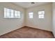 Well-lit bedroom with neutral carpet and two windows at 7732 Prosperity River Ave, Las Vegas, NV 89129