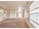 Open living room with neutral carpet, ceiling fan, and plenty of natural light at 7732 Prosperity River Ave, Las Vegas, NV 89129