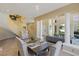 Open concept dining room with a gray table, tile floor, and views into living room, entry way, and staircase at 8320 Carmel Ridge Ct, Las Vegas, NV 89113