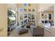 Bright living room features a large gray sofa, media center with two TVs, and a wall of large windows at 8320 Carmel Ridge Ct, Las Vegas, NV 89113