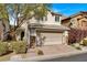 Two-story house with a two-car garage and landscaped front yard at 8960 Fox Season Ave, Las Vegas, NV 89178