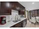 Modern kitchen with dark cabinetry, stainless steel appliances, and a breakfast nook at 10009 Delicate Dew St, Las Vegas, NV 89183