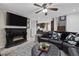 Living room with black leather sectional, electric fireplace, and large TV at 10009 Delicate Dew St, Las Vegas, NV 89183