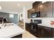 Modern kitchen features dark cabinetry, stainless steel appliances, and an island at 1004 Huckburn Ave, Henderson, NV 89015