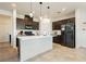 Modern kitchen with dark cabinets, island, and stainless steel appliances at 1004 Huckburn Ave, Henderson, NV 89015