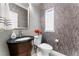 Elegant powder room with dark vanity and patterned wallpaper at 10452 Acclamato Ave, Las Vegas, NV 89135