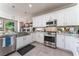 Modern white kitchen with stainless steel appliances and granite countertops at 10452 Acclamato Ave, Las Vegas, NV 89135