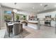 Modern kitchen with white cabinets, marble countertops, and breakfast bar at 10452 Acclamato Ave, Las Vegas, NV 89135