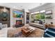 Elegant living room with fireplace and large windows overlooking the backyard at 10452 Acclamato Ave, Las Vegas, NV 89135