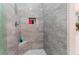 Modern shower with gray tile, built-in shelves, and a corner seat at 10452 Acclamato Ave, Las Vegas, NV 89135