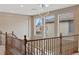 Hallway landing with elegant chandelier viewed from staircase, bright and airy at 1067 Via Saint Andrea Pl, Henderson, NV 89011