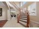 Staircase with a wooden banister leads from the entryway to the upstairs living areas at 1067 Via Saint Andrea Pl, Henderson, NV 89011