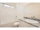 Bathroom featuring a tub, granite countertop, white cabinets, and a sink at 10923 Stone Crossing Ave, Las Vegas, NV 89166