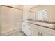 Bathroom with double sinks, granite countertop, white cabinets, and walk-in shower at 10923 Stone Crossing Ave, Las Vegas, NV 89166