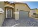 Close-up of the home's front entrance, featuring an elegant walkway and a gray garage door at 10923 Stone Crossing Ave, Las Vegas, NV 89166