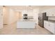 Well-lit kitchen boasts a central island, white cabinetry, and modern stainless steel refrigerator at 10923 Stone Crossing Ave, Las Vegas, NV 89166