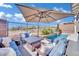 Comfortable patio with seating area, fire pit, and large umbrella at 12073 Glentana View St, Las Vegas, NV 89138