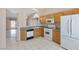 Kitchen with oak cabinets, white appliances, and tile flooring at 1226 Sunfire St, Henderson, NV 89014