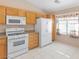 Kitchen with oak cabinets, white appliances, and tile flooring at 1226 Sunfire St, Henderson, NV 89014