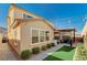 Backyard view with a covered patio, grill, green grass, and meticulous landscaping at 12898 Slipknot St, Las Vegas, NV 89141