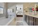 Bathroom featuring double sinks, a soaking tub, and a view into the main bedroom at 12898 Slipknot St, Las Vegas, NV 89141