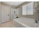 Bathroom featuring a soaking tub, glass shower and a bright window at 12898 Slipknot St, Las Vegas, NV 89141