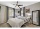 Bedroom featuring a ceiling fan, decor, large mirror, and natural light from two windows at 12898 Slipknot St, Las Vegas, NV 89141