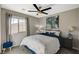 Bedroom with a ceiling fan, window views, and blue accents throughout the room at 12898 Slipknot St, Las Vegas, NV 89141