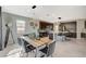 Modern dining room with rustic wood table, chandelier lighting, and an adjacent kitchen at 12898 Slipknot St, Las Vegas, NV 89141