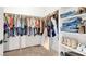 Walk-in closet filled with folded jeans, shirts and shoes and carpeted floor at 1920 Cavalry St, Pahrump, NV 89048