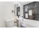 Modern bathroom with dark tile and a white bathtub and sink at 214 W Atlantic Ave, Henderson, NV 89015