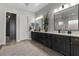 Double vanity bathroom with dark wood cabinets, quartz countertops, and a large mirror at 23 Via Tavolara, Henderson, NV 89011