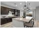 Modern kitchen with dark cabinetry, granite countertops, and a large island at 23 Via Tavolara, Henderson, NV 89011