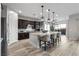 Dark wood cabinetry, granite island, and stainless steel appliances in a modern kitchen at 23 Via Tavolara, Henderson, NV 89011