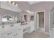 Bathroom with double vanity sinks, jacuzzi tub, tiled floors, and decor lighting, providing a relaxing retreat at 2413 Cook Out Ct, Henderson, NV 89002