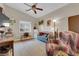 Bright living room with natural light, ceiling fan, desk, vintage furnishings and charming decor at 2413 Cook Out Ct, Henderson, NV 89002