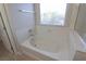 Relaxing bathtub with window and marble accents at 242 Botanic Gardens Dr, Las Vegas, NV 89148