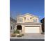 Two-story house with beige exterior, attached garage, and landscaping at 242 Botanic Gardens Dr, Las Vegas, NV 89148