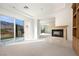 Bright living room featuring a fireplace, balcony access, and mountain views at 2475 Grassy Spring Pl, Las Vegas, NV 89135