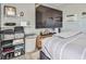 This back house bedroom includes a large television, shelving, and window air conditioning at 2540 Eagle St, Las Vegas, NV 89142