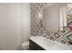 Stylish powder room with geometric tile and a gold framed mirror at 2669 Pioneer Estates Ct, Las Vegas, NV 89117