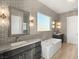 Primary bathroom with soaking tub, double vanity and designer wallpaper at 2669 Pioneer Estates Ct, Las Vegas, NV 89117