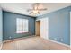 Blue-walled bedroom with ceiling fan and closet at 303 Glasgow St, Henderson, NV 89015