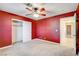 Bedroom with red walls, ceiling fan and carpet at 303 Glasgow St, Henderson, NV 89015