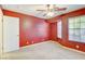 Bedroom with red walls, ceiling fan, and carpet at 303 Glasgow St, Henderson, NV 89015