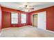 Bedroom with red walls, ceiling fan, and carpet at 303 Glasgow St, Henderson, NV 89015