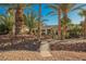 Backyard oasis with palm trees and a wooden bridge at 328 Hedgehope Dr, Las Vegas, NV 89183